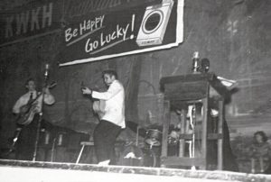 black and white photo of Elvis Presley performing on the Louisiana Hayride stage