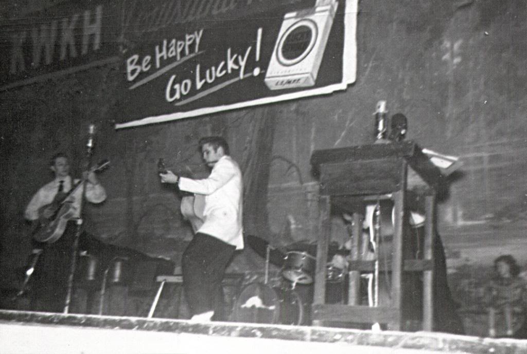 black and white photo of Elvis Presley performing on the Louisiana Hayride stage